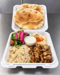Chicken shawarma plate with rice, hummus, salad, pickled turnips, garlic sauce, and pita